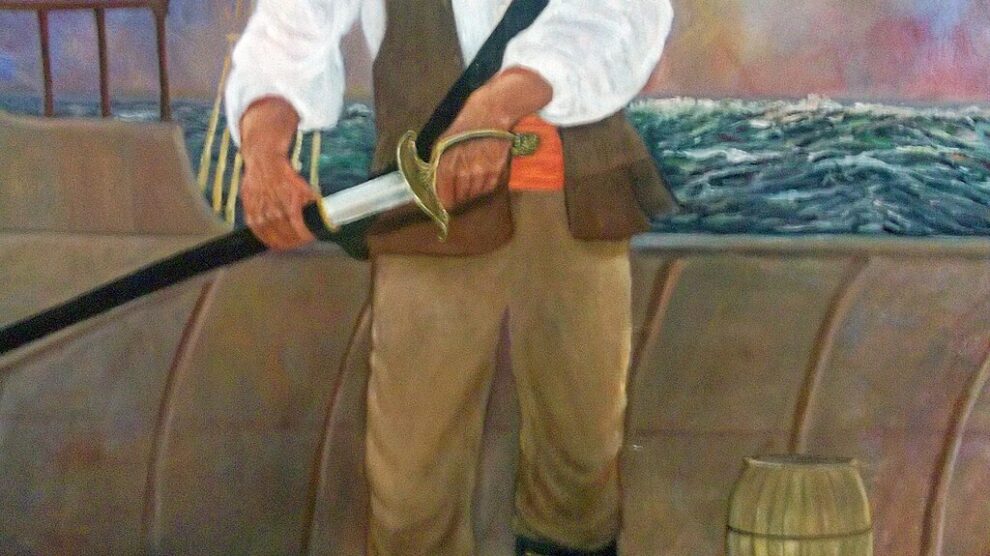 Painting of Puerto Rican pirate Roberto Cofresí standing aboard a ship holding a sword, wearing a red headscarf, white shirt, and brown vest and trousers, with a stormy sea and sky in the background.