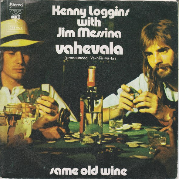 "Cover of the single 'Vahevala' by Kenny Loggins and Jim Messina, showing the duo sitting at a poker table with cards, drinks, and a bottle of wine." Description: "This is the cover art for the single 'Vahevala' by Kenny Loggins and Jim Messina. It depicts the duo seated at a poker table surrounded by cards, glasses, and a bottle of wine, capturing a relaxed and casual vibe. The text prominently displays the title 'Vahevala' with a pronunciation guide (Va-hee-va-la) and also includes the title of the B-side track, 'Same Old Wine.'"