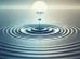 Image of a calm water surface with a ripple effect emanating outward from a single drop of water, symbolizing tranquility and interconnectedness.