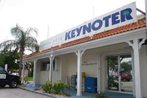 Florida Keys Keynoter building in Marathon, Florida, with a sign featuring the newspaper's name and a palm tree graphic.