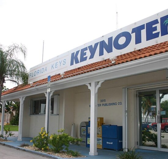 Florida Keys Keynoter building in Marathon, Florida, with a sign featuring the newspaper's name and a palm tree graphic.