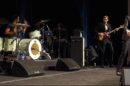 The Killers performing live in Las Vegas, featuring Brandon Flowers singing, Ronnie Vannucci Jr. on drums, and Mark Stoermer on bass.