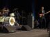 The Killers performing live in Las Vegas, featuring Brandon Flowers singing, Ronnie Vannucci Jr. on drums, and Mark Stoermer on bass.