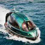 Futuristic green Jet Capsule mini-yacht cruising on open water with passengers visible inside