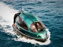 Futuristic green Jet Capsule mini-yacht cruising on open water with passengers visible inside
